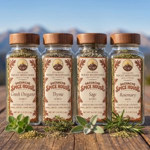 Herb Garden Collection: four Saguache Spice House jars of Greek oregano, thyme, sage and rosemary on a wooden table
