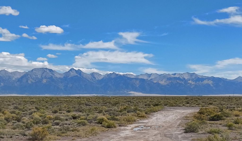 Dirt road through sagebrush toward the Sangre de Cristo Mountains in Colorado’s San Luis Valley.